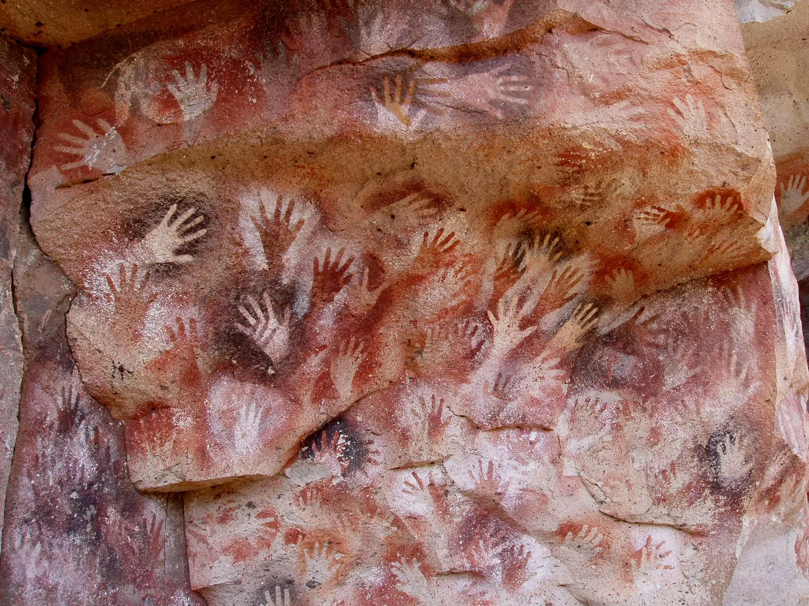 Cueva de las Manos, Santa Cruz, Argentina – outlines of many human hands on a rock wall.